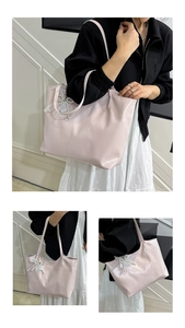 Detail of pink glossy tote bag featuring pearl lace bow and spacious interior design