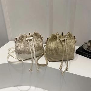 Minimalist straw woven bucket bag with faux leather拼接 and drawstring closure in neutral tones