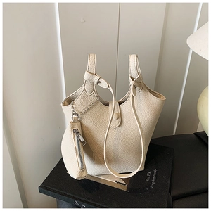 Detail of beige lychee textured bucket bag with matching detachable coin purse and shoulder strap