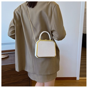 Detailed view of white floral embossed box bag with gold frame and metal chain strap