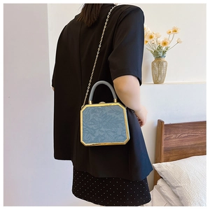 Detail of vintage morandi blue embossed floral bag with elegant gold metal frame