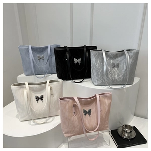 Detail shot of collection of textured tote bags with metallic butterfly ornaments