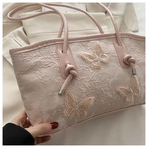 Detail of pink lace tote bag featuring 3D butterfly embroidery and knotted handle design