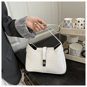 Close-up of white crocodile texture leather bag featuring silver chain and rotary lock