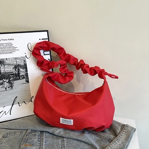 Sac bandoulière en nylon rouge avec bandoulière froncée et étiquette de marque sobre