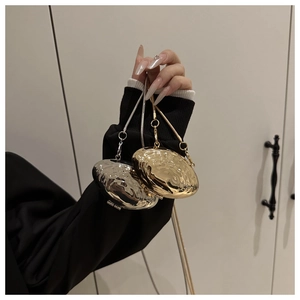Détail de mini sacs métalliques en forme de coquille dorés et argentés avec chaîne serpent