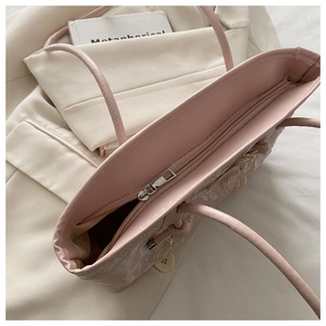 Detail view of pink tote bag with floral embroidery and silver zipper closure