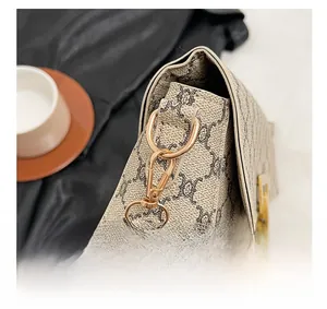 Macro view of vintage patterned beige shoulder bag with gold-tone D-ring hardware details