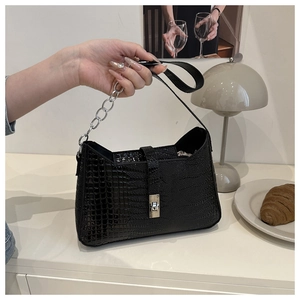 Close-up of black crocodile pattern faux leather with silver metal rotating lock and chain