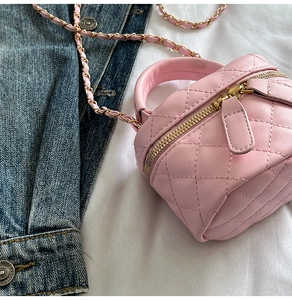 Detailed view of pink quilted mini bag with chain strap and soft leather texture