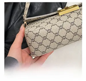 Detail showing the precision stitching and vintage monogram pattern of the crossbody bag
