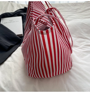 Detail of red and white striped canvas tote bag with thick handles for daily use