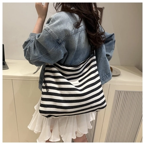 Close-up of black and white striped canvas tote bag with long slim shoulder straps