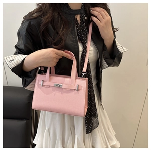 Pink lychee grain leather crossbody bag with silver twist lock shown on model