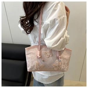 Detail of light pink tote bag with lace texture and 3D butterfly embroidery details