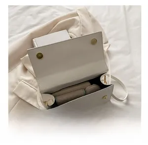 Interior view of small square bag showing storage capacity for phone and cosmetics