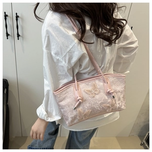 Detail of pink lace tote bag with delicate butterfly embroidery and knotted handle