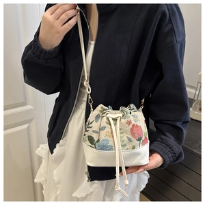 Close-up of floral jacquard embroidery and drawstring closure on the bucket bag