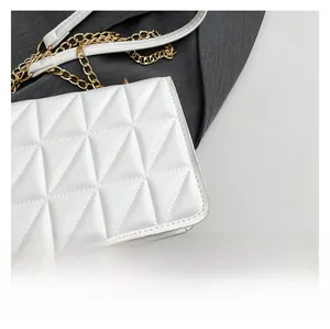 Detail of white geometric quilted leather texture and golden metal chain shoulder strap