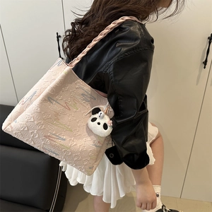 Light pink embroidered tote bag with diamond texture and panda charm shown on model