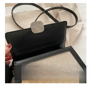 Close-up of the metal magnetic buckle on a woven contrast color crossbody bag