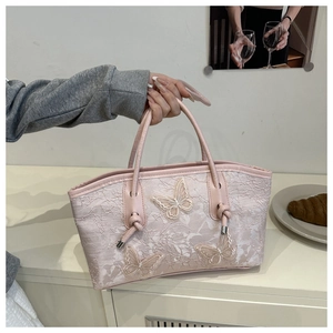 Close-up of pink lace tote bag featuring 3D butterfly appliques and knotted handle