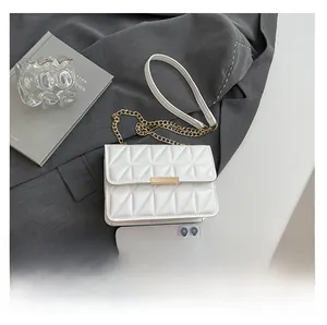 White quilted crossbody bag with gold chain and smartphone for size reference