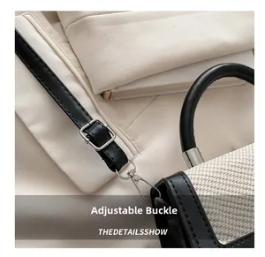 Detail of adjustable leather strap with silver buckle on beige woven crossbody bag