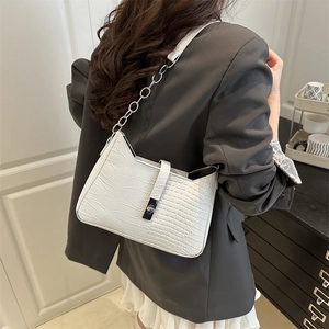 White faux crocodile skin crescent shoulder bag with silver chain strap on model