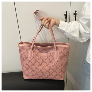 Detailed view of pink floral tote bag with large capacity, showing texture and gold label