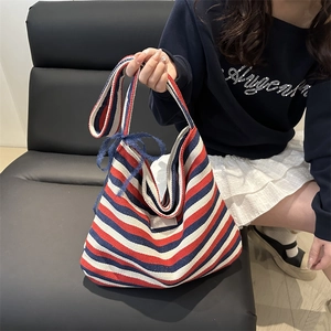Striped canvas tote bag with red, white, and blue patterns and a lace bow decoration