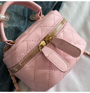 Detail view of pink quilted leather box bag with gold chain strap and dual zippers