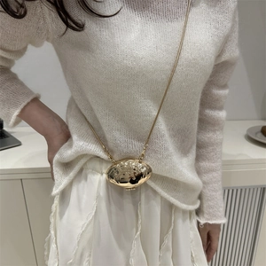 Mini sac élégant en métal doré en forme de coquillage avec chaîne sur tenue en tricot