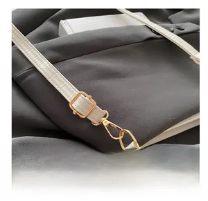 Détail de la bandoulière en cuir blanc motif crocodile avec boucle dorée ajustable
