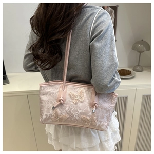Detail of light pink lace tote bag with 3D butterfly embroidery and slim shoulder straps