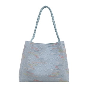 Light blue quilted tote bag with colorful embroidery and braided handle for women