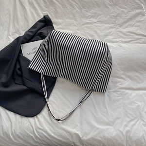 Minimalist black and white striped canvas tote bag on a white textured background