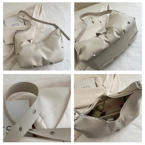 Detail view of large capacity beige crossbody bag showing interior space and hardware