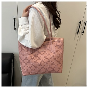Elegant pink tote bag with floral patterns shown on a model's shoulder in a minimal setting