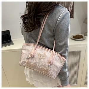 Pink lace tote bag with butterfly embroidery shown on shoulder in a casual setting