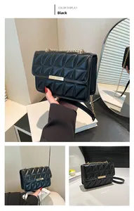 Detail of black quilted shoulder bag featuring gold clasp and chain strap craftsmanship