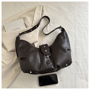 Detail of vintage dark brown faux leather shoulder bag with star rivets and adjustable strap