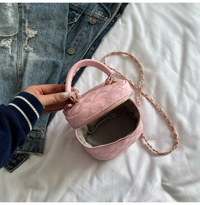 Detail view of pink quilted leather mini box bag with gold chain strap and metal zipper