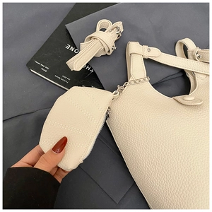 Detail of off-white lychee pattern bucket bag with detachable pouch and long shoulder strap
