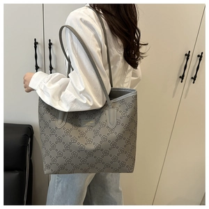 Detailed view of grey tote bag with elegant floral pattern and shoulder strap