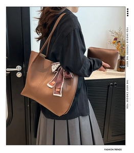 Détail d'un grand sac fourre-tout marron avec foulard en soie et pochette assortie.