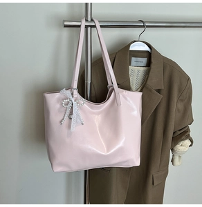 Detail of light pink tote bag with elegant white lace and pearl bow charm accessory