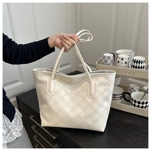 Close-up detail of cream large capacity tote bag featuring elegant embossed flower patterns