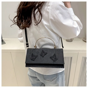 Lace crossbody bag with 3D butterfly embroidery and gold metal handle worn by model