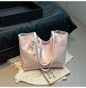 Dettaglio della borsa tote in PU rosa lucido con perle e ciondolo in pizzo bianco